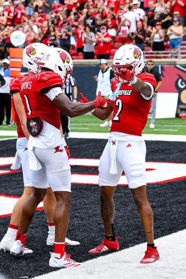 Louisville Football player Jadon Thompson (2) celebrates after a touchdown with Ja'Corey Brooks (1) and Tyler Shough (9).