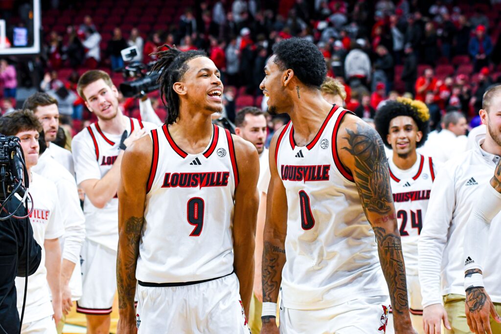 Khani Rooths and James Scott celebrate after a win; Louisville basketball. Photo by Jared Anderson.