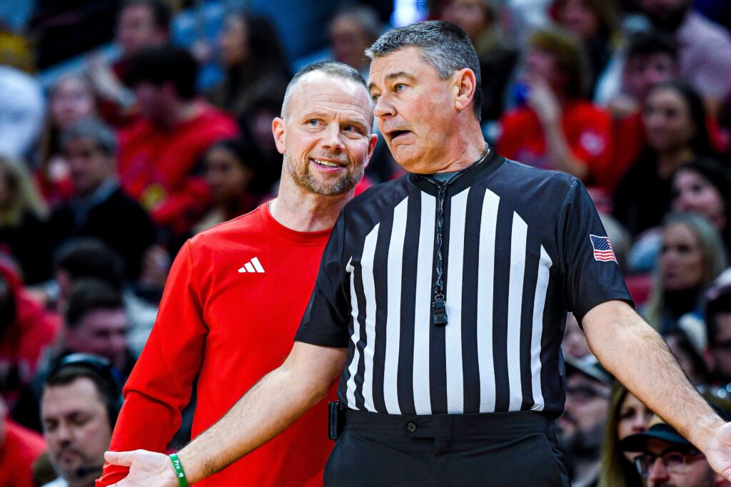 Louisville basketball head coach Pat Kelsey chats with an official. Photo by Jared Anderson.