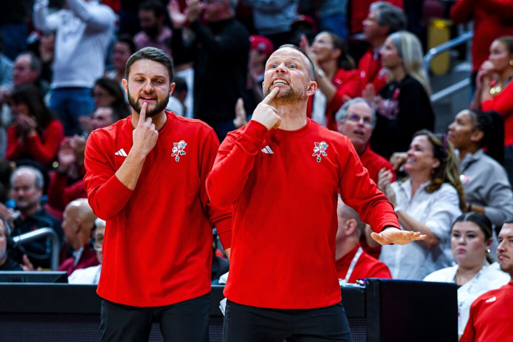 Louisville head coach Pat Kelsey and assistant Thomas Carr watch from the sidelines. 