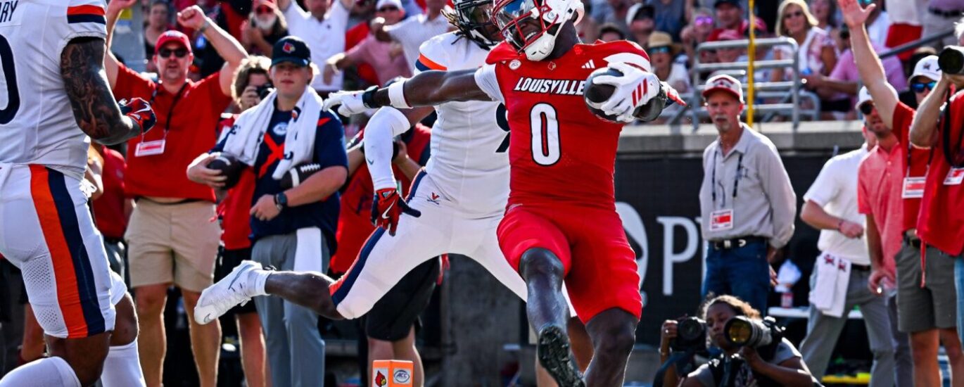 Louisville football wide receiver Chris Bell escapes defenders entering the endzone.