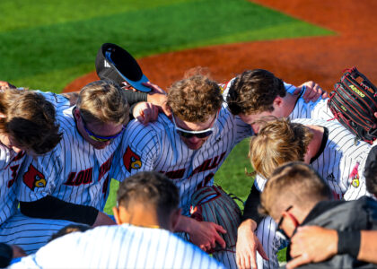Louisville Baseball huddles together outside of the First Base Dugout Photo by Jared Anderson